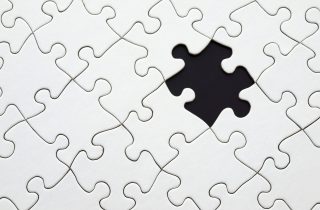 Close-up of an incomplete white puzzle with one missing piece, symbolizing challenge and strategy.